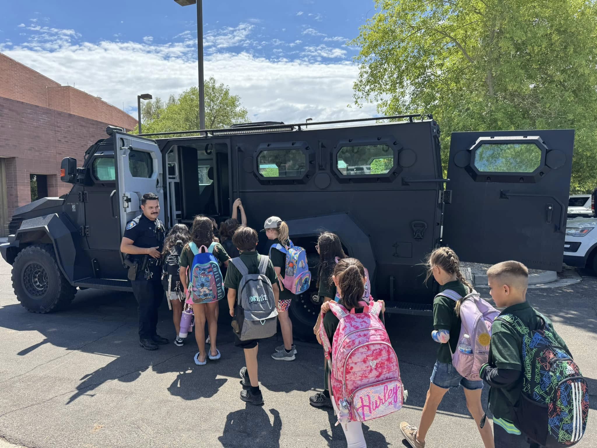 officer showing children the swat truck on a tour