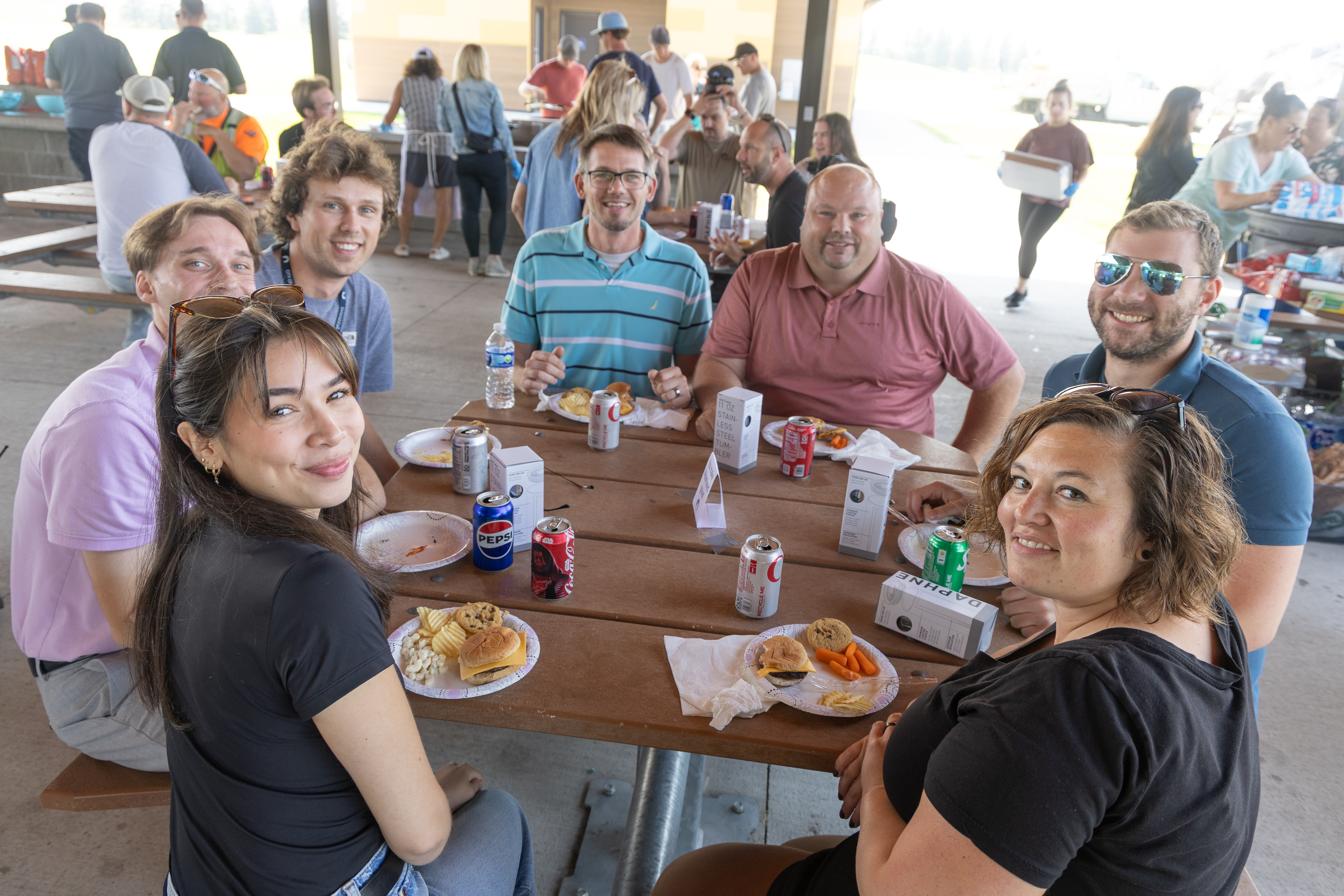 staff enjoy food around a picnic table