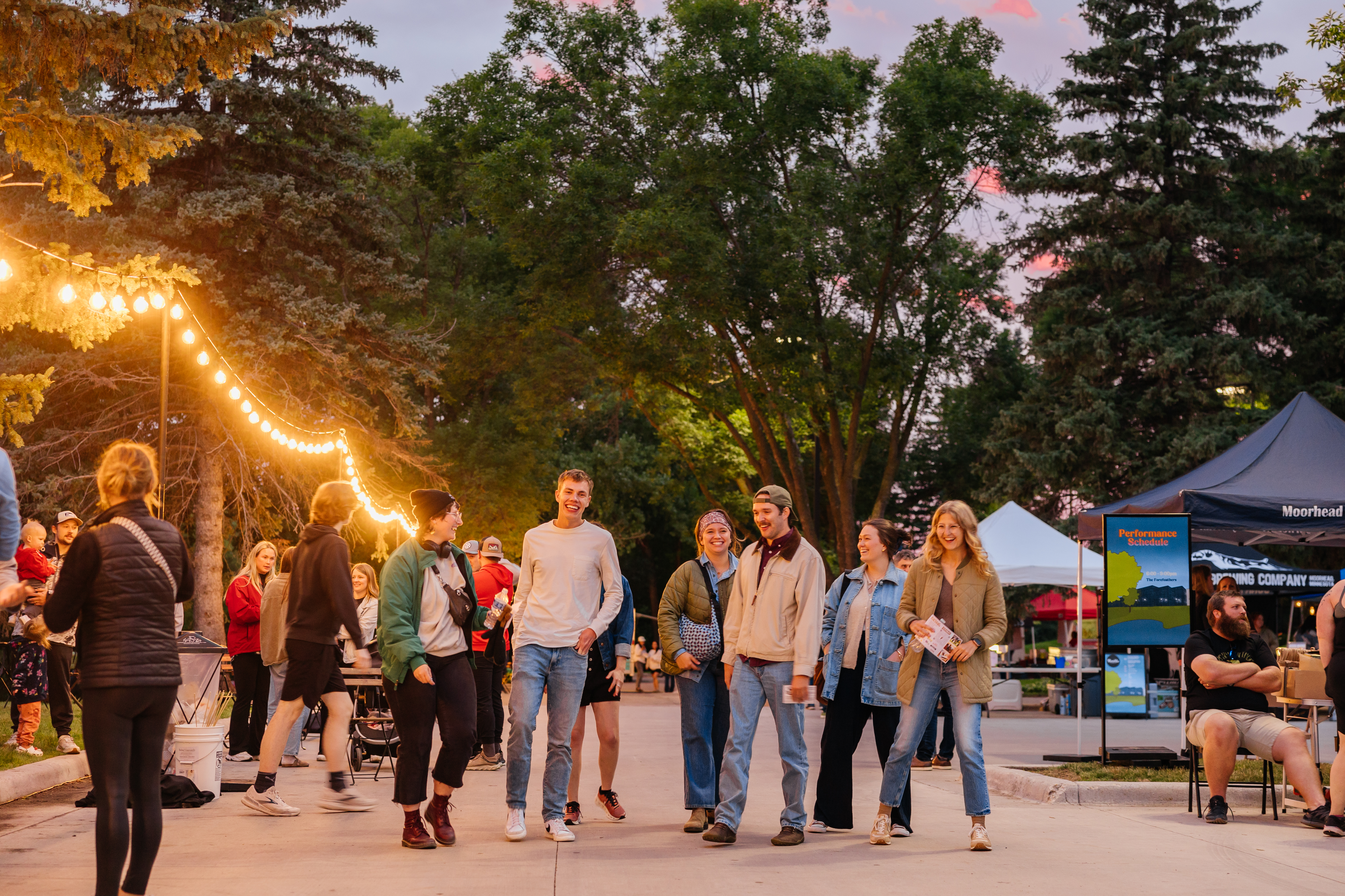 People walk at sunset at an event